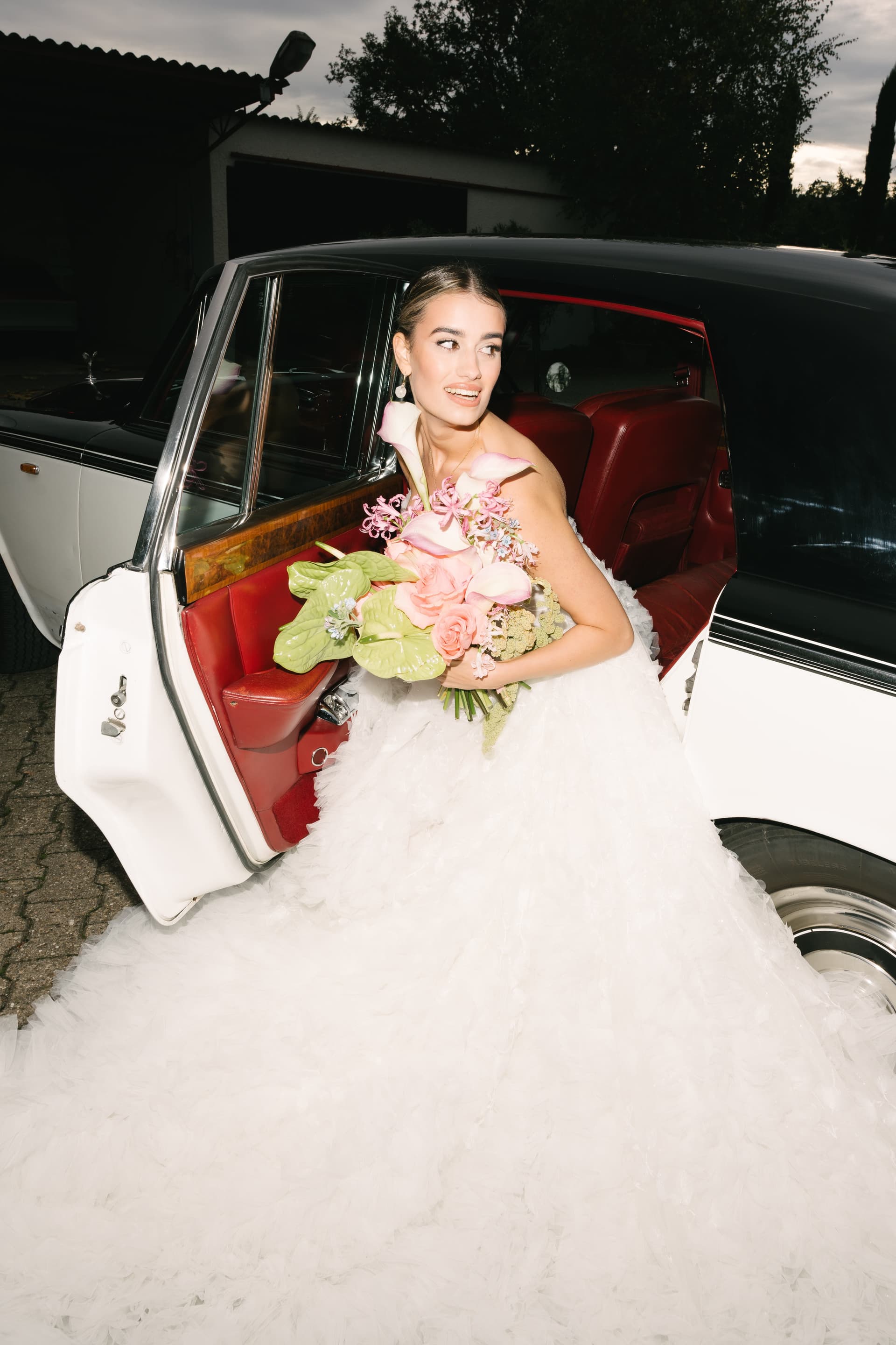 Braut im eleganten Oldtimer mit Brautstrauß